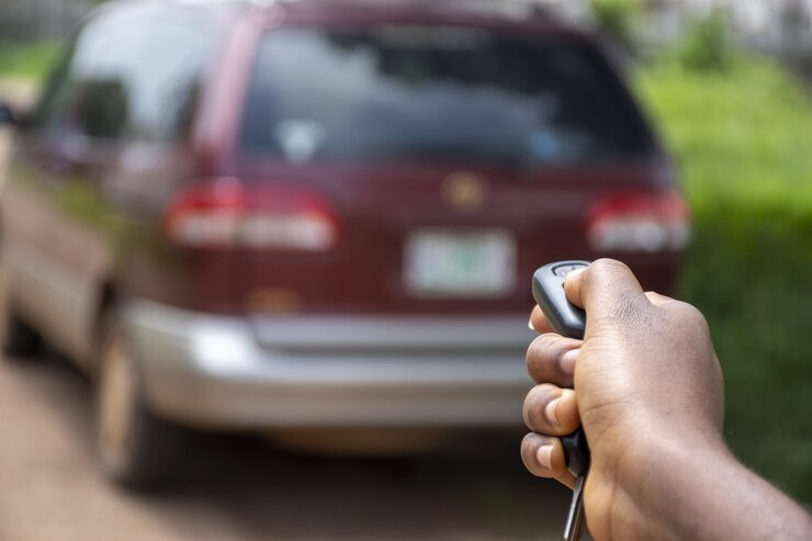 Person pointing a key fob at their car, attempting to unlock it